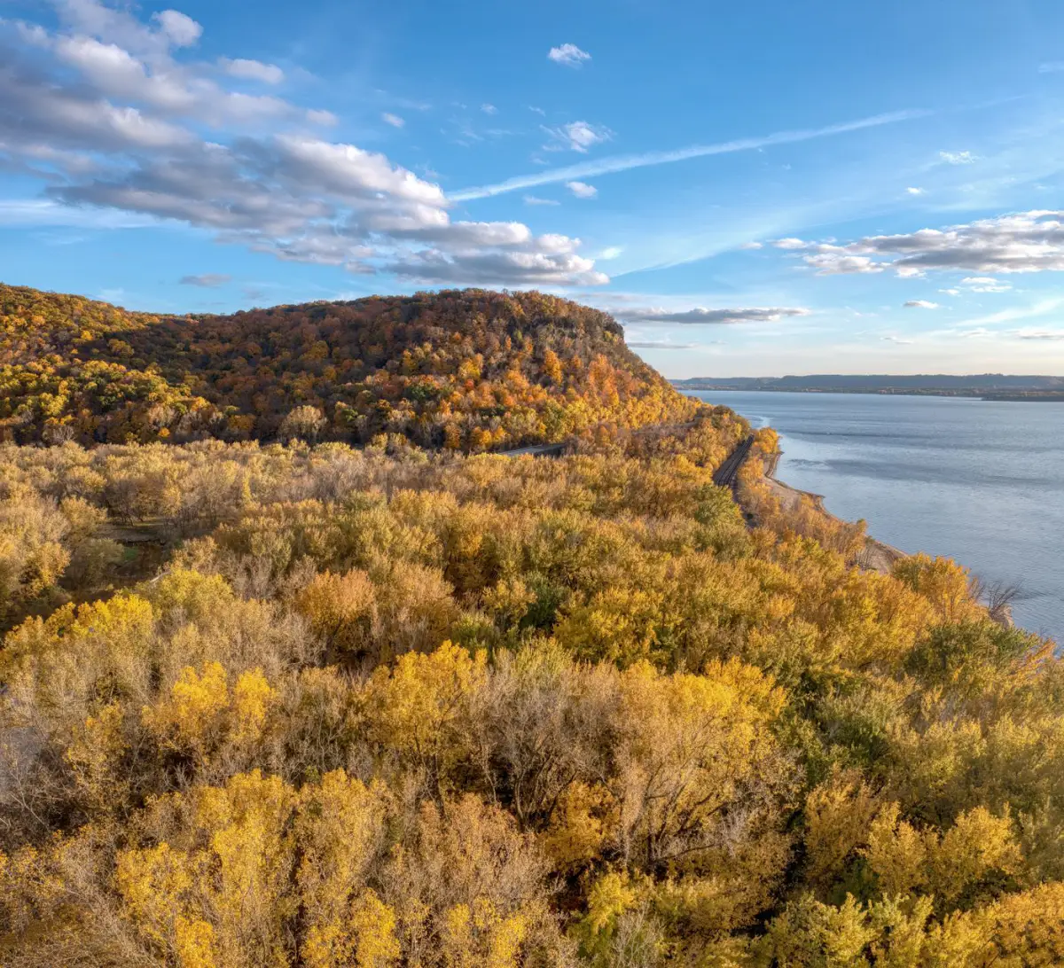 Wooded bluffs in autumn colour dropping to the water along Lake Pepin on the Mississippi