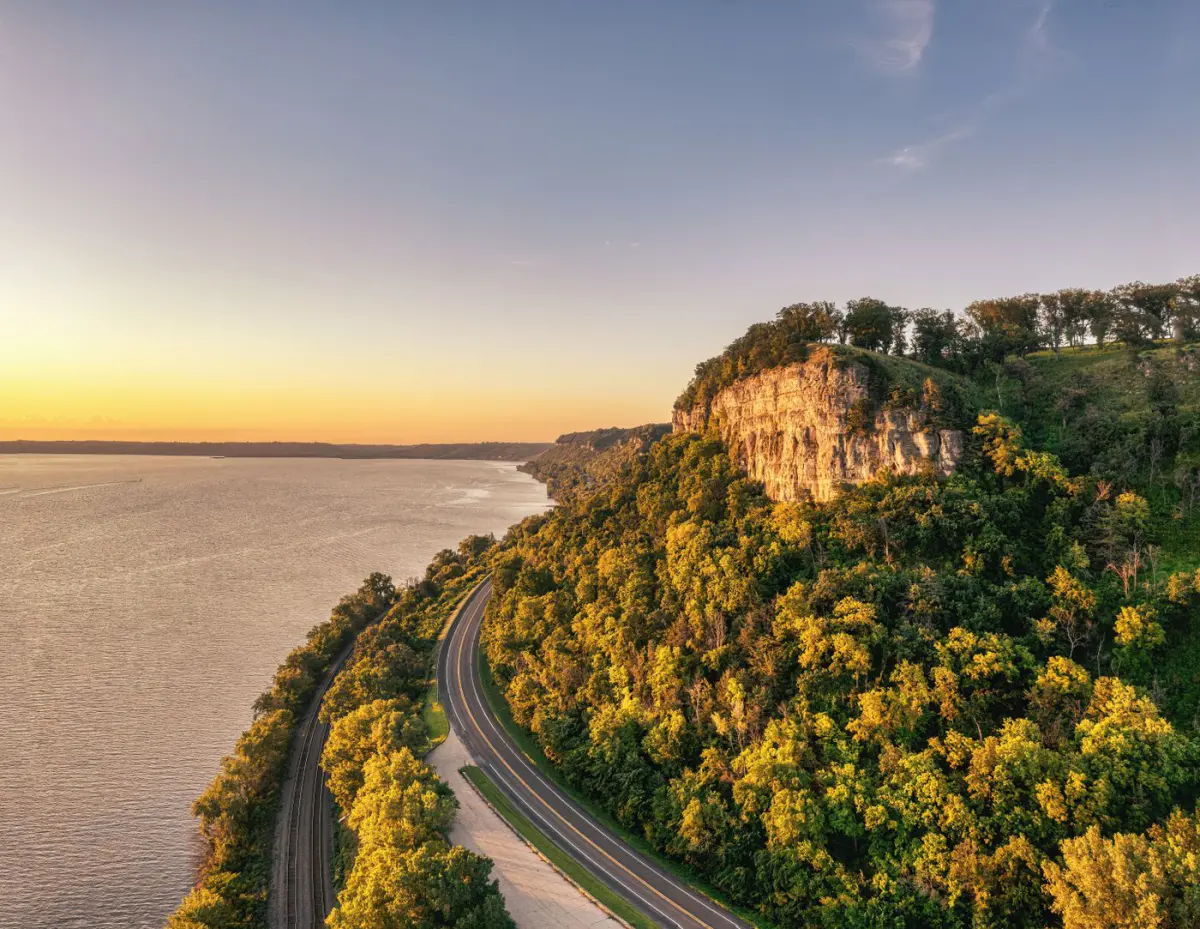 Limestone bluffs carrying hardwood timber down to the Mississippi River at sunset in the Driftless country