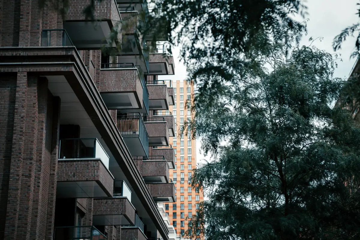 Brick multi-family residential buildings surrounded by established green tree canopy